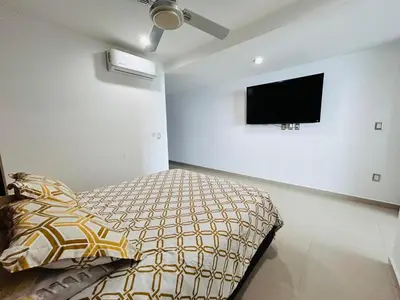Una televisión o centro de entretenimiento en depa vista al atardecer y a pie de playa by G P S rentas