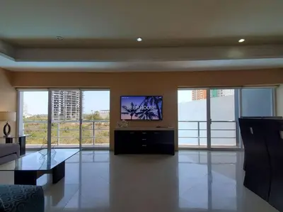Una televisión o centro de entretenimiento en Grande Condo 1 Cuadra de Playa