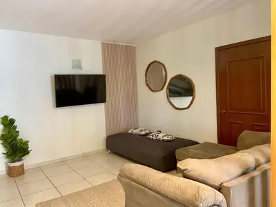 Una televisión o centro de entretenimiento en Hermoso condominio frente al mar