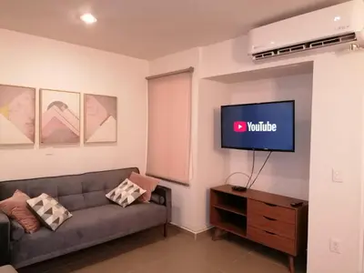 Una televisión o centro de entretenimiento en Excelente Departamento con Alberca cerca de Playa - Residencial Coto Mareta I